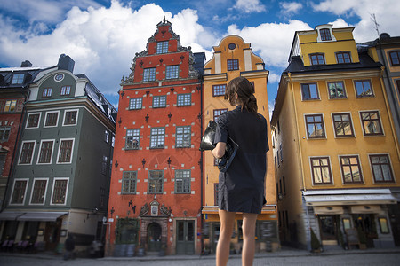 名妇女站斯德哥尔摩房屋的背景上瑞典图片