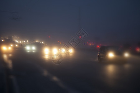 晚上,路灯的灯光下,汽车雾中行驶图片