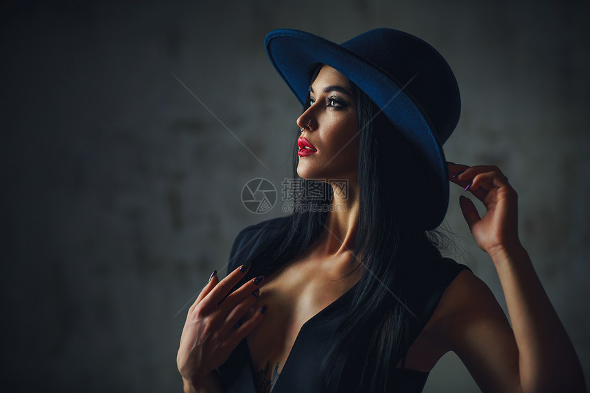 轻优雅的黑发女人戴着帽子肖像身上纹身,脸上穿孔图片