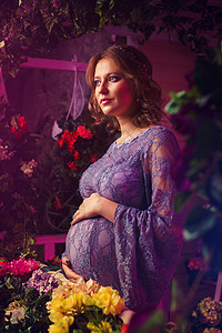 轻的孕妇温柔的肖像房子里很多花背景图片