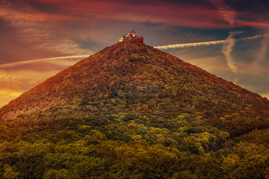 城堡高山顶部与森林日落红色图片