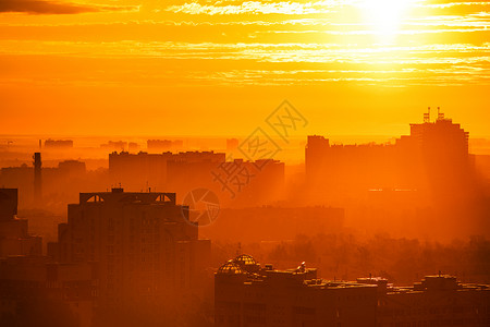 温暖的夏季早晨日出的灯光下,城市的轮廓图片