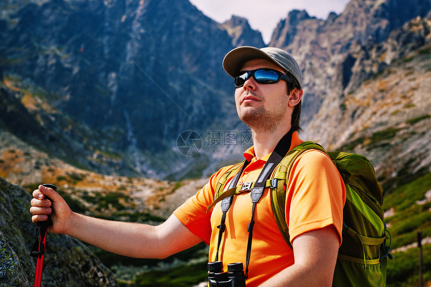 轻人游客,绿色背包太阳镜肖像高山背景图片