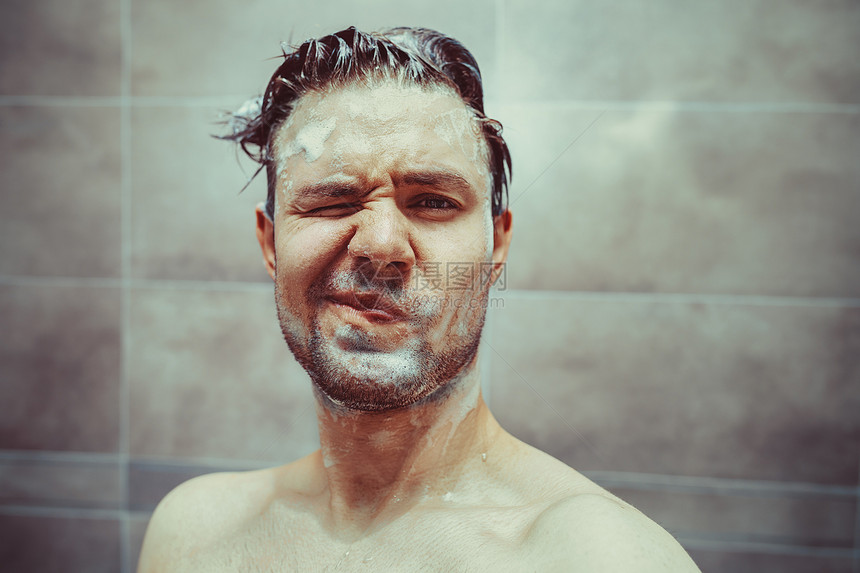 轻人浴室肖像中用洗发水洗头快乐的情绪图片