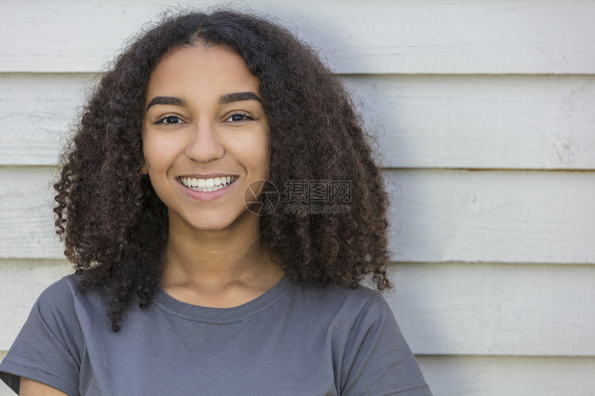 户外肖像美丽的快乐混合种族非裔美国女孩十几岁的女孩子微笑与完美的牙齿图片