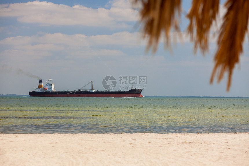 油轮航行空的热带海滩与棕榈树白沙图片