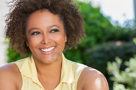 美丽的轻混血黑人非裔美国妇女,完美的牙齿,微笑放松外的夏季阳光背景图片