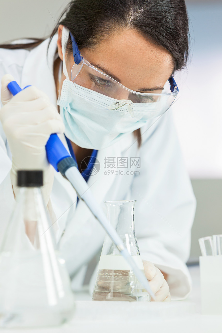 位女医学科学研究员科学家,实验室里用吸管烧瓶,身后台电脑器图片