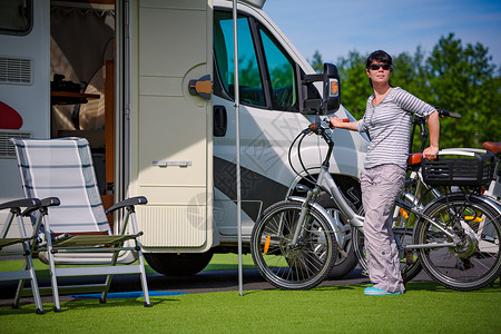 露营车附近的自行车旁边的女人房车度假家庭度假旅行,汽车之家度假旅行图片