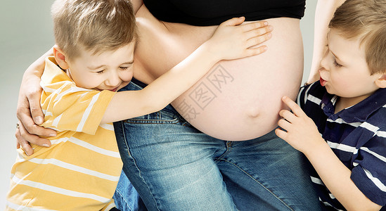 小可爱的儿子抚摸着怀孕母亲的肚子图片