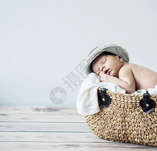 可爱的小男孩睡柳条篮子里图片