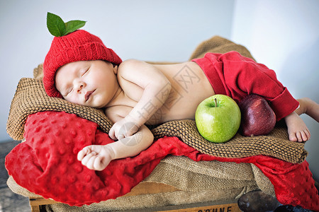 可爱的新生儿睡柔软的红色毯子上图片