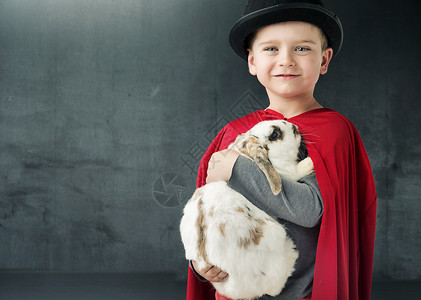 小魔术师抱着只神奇的兔子背景图片