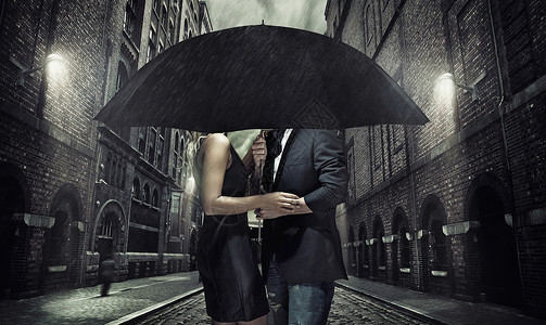黑色雨伞下的可爱夫妇图片