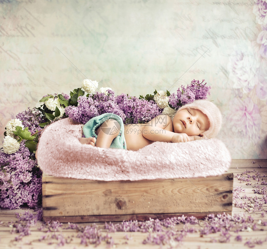 熟睡的蹒跚学步的孩子躺紫色的花毯子上图片