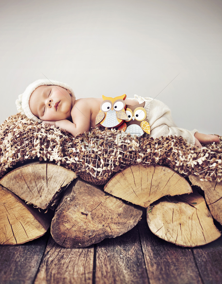 睡木头上的蹒跚学步的孩子的肖像图片