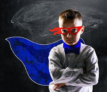学校男孩穿着超级英雄服装,身后黑板超级英雄学校男孩图片