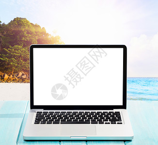 现代笔记本电脑蓝色木制桌子与空白屏幕热带海滩海边工作图片