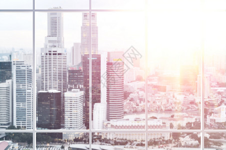 办公室窗口查看办公室窗口观看现代新加坡市中心摩天大楼的日落景色图片