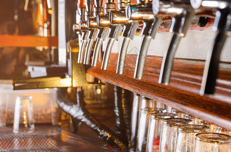 柜台后的酒保工作场所排啤酒水龙头空璃杯排啤酒水龙头图片