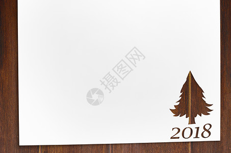 桌子上用冷杉树形状切纸木桌上剪下2018诞卡新背景的冷杉树形状的纸图片