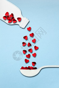 创意情人节照片的瓶子勺子制成的纸与心蓝色背景背景图片
