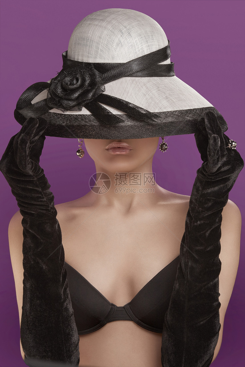 位漂亮的轻女士戴着顶时髦的遮阳帽,黑色比基尼长手套图片