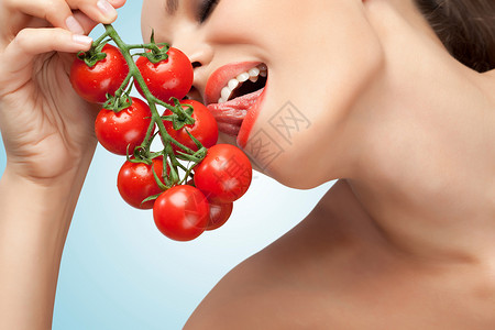 张感女人用舌头舔堆樱桃西红柿的创意照片图片