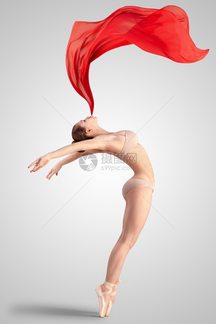 位优雅的女古典芭蕾舞穿着米色内衣的尖鞋,踮脚尖平衡,中灯光工作室背景上呼出红色物,就像火焰样图片