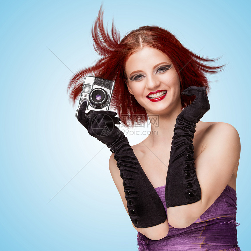 迷人的微笑女孩,戴着长手套,着台老式照片相机,蓝色背景上说奶酪图片
