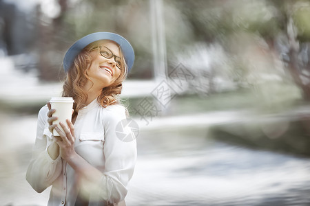 快乐的轻时尚女人购物后休息咖啡,微笑着夏天的公园里手里着咖啡图片