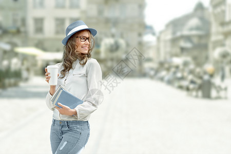 快乐的轻学生,喝着咖啡,着书城市背景下阅读学图片