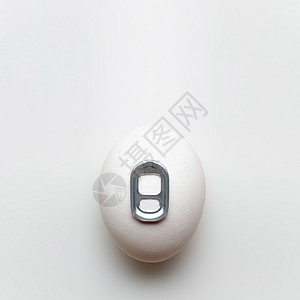 创意静物照片的鸡蛋与罐头钥匙白色背景图片
