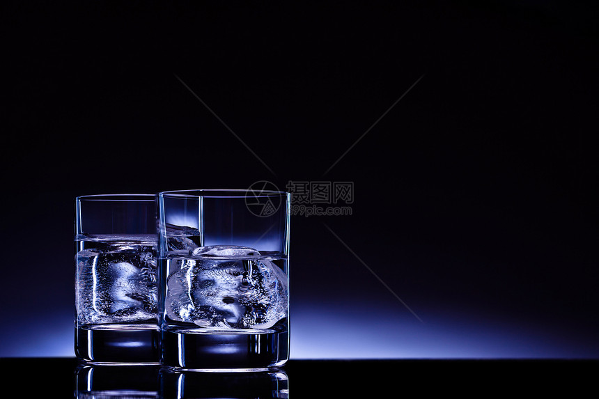 两杯伏特加加冰块,背景深蓝色的辉光图片