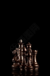 战略领导理念黑色木制国际象棋人物站,个家庭,准备黑暗的背景下进行游戏图片