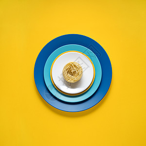 厨房用具的创意照片,黄色背景上画食物的盘子图片