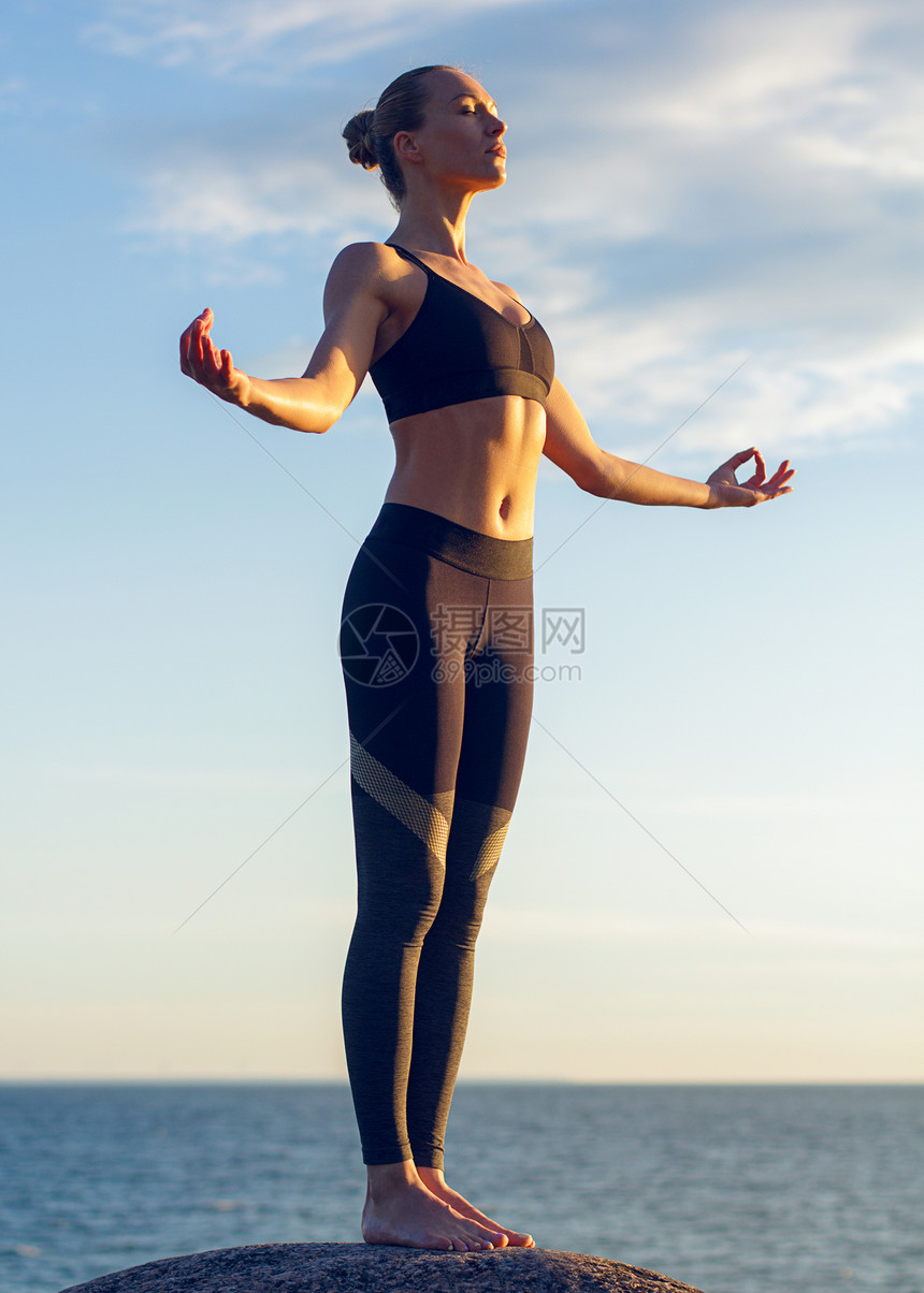 高加索健身妇女练瑜伽轻的白种人健身妇女海边练瑜伽图片