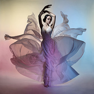 艺术时尚工作室照片美丽优雅的女人衣服会飞的裙子自由xa颜色的绘制光颜色的影响流动服装的时尚风格背景图片