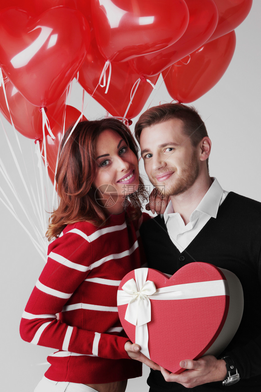相爱的夫妇快乐拥抱相爱的夫妇,着情人节礼物堆心形气球图片