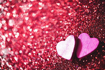 两颗心闪闪发光两颗木制的心红色发光的波基心背景上为情人节背景图片