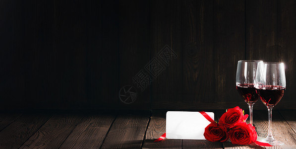 两杯红酒,红玫瑰木制背景上的空白卡高清图片