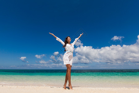 海滩上举手臂的女人快乐的女人热带海滩举手臂图片