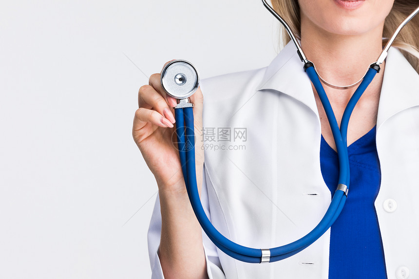 带听诊器的医生女医生手持听诊器,浅灰色背景,图片