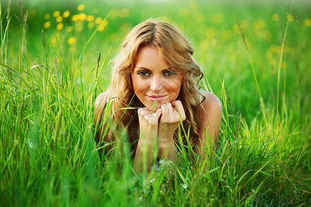 金发轻女子躺绿色的草地上金发草地上图片