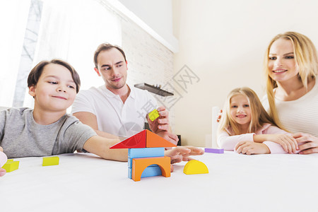 孩子的家庭建造房子家庭四人带着孩子建造玩具积木,房地产图片