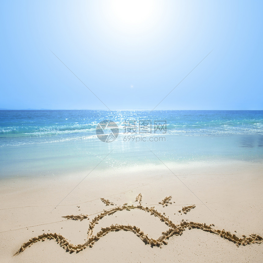 沙滩上画太阳金色沙滩上画波浪炎热的夏日太阳,上热带海滩上度假图片