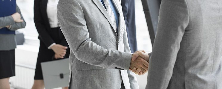 商人握手商人握手,完成办公室的会议背景图片