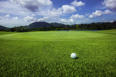 球场上的高尔夫球球场上的高尔夫球,背景上山的美丽景观背景图片