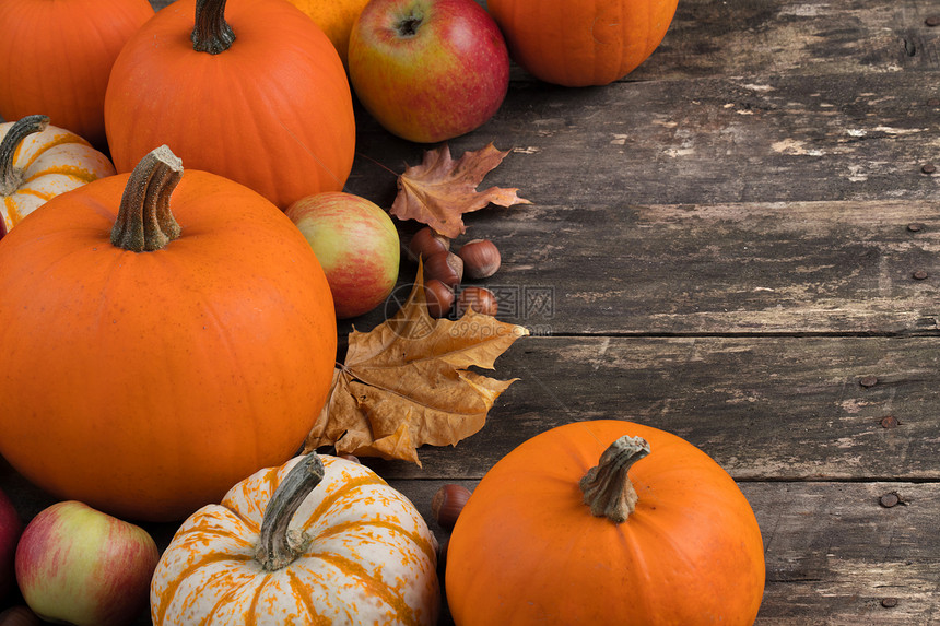 木桌上的秋收秋收生活与南瓜,苹果,榛子枫叶木制的背景图片