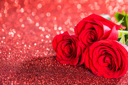 闪光的红玫瑰三朵美丽的红玫瑰闪光的背景上背景图片